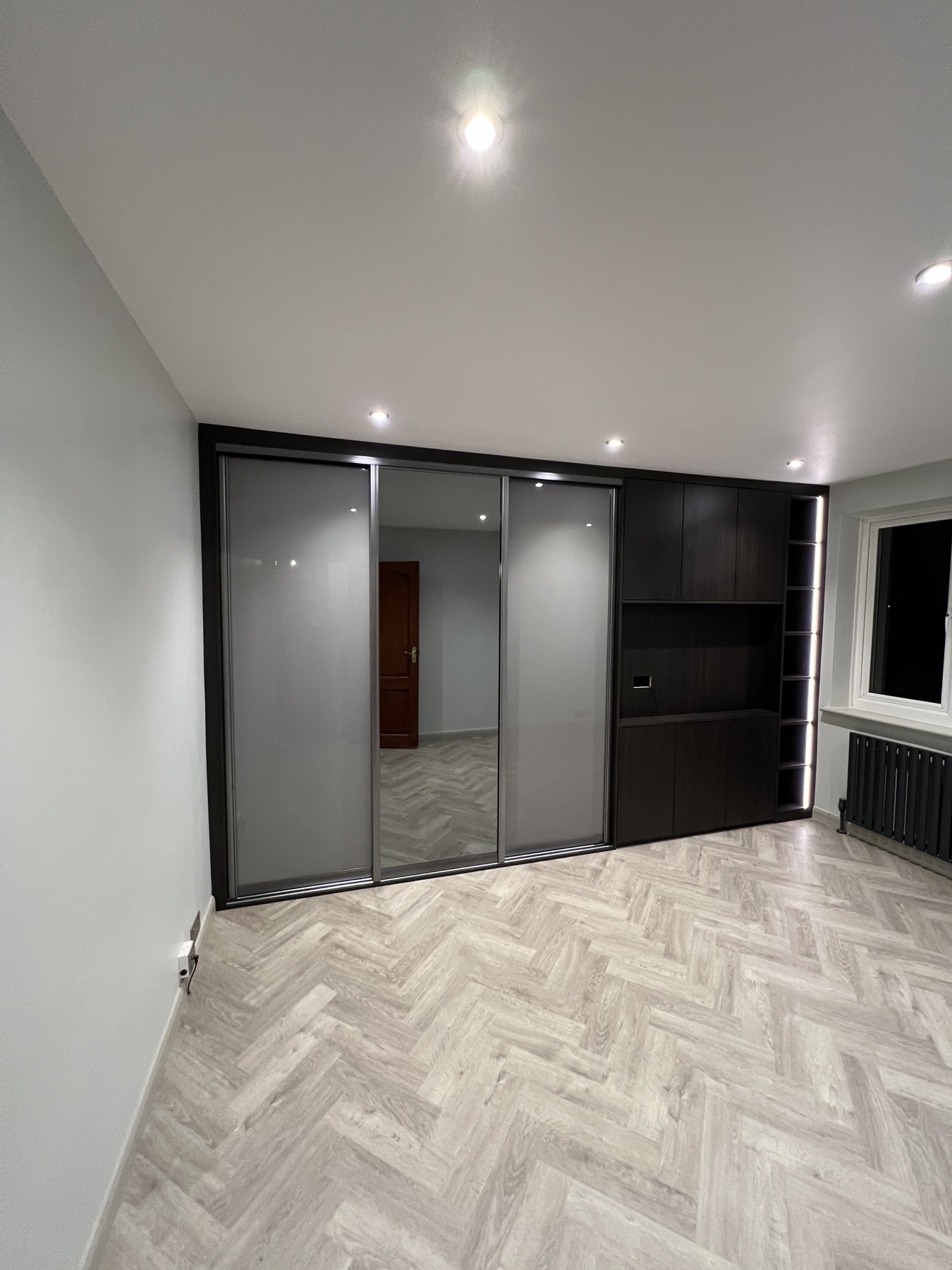 Completed wall-to-wall sliding wardrobes with integrated cabinetry